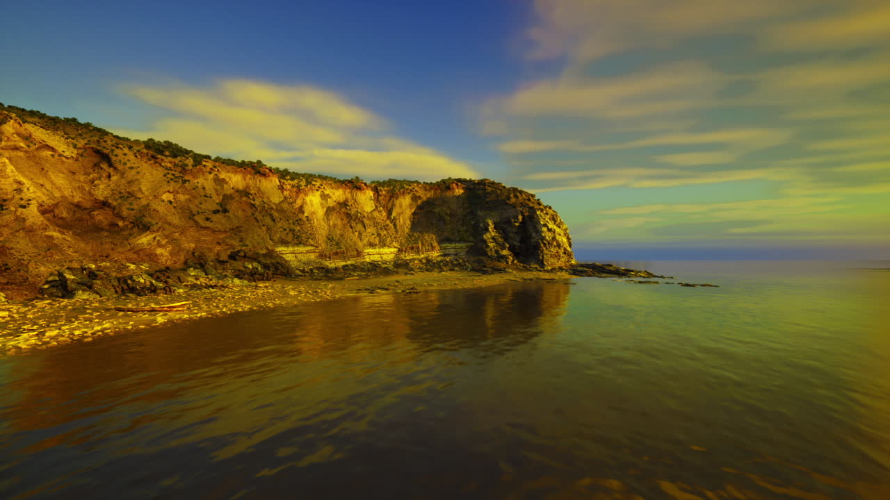 Acantilados reflejándose dramáticamente en el agua bajo una puesta de sol colorida