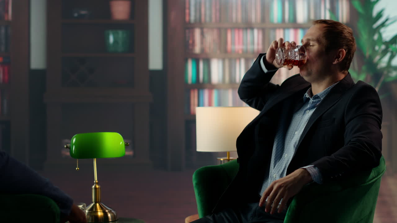 높은 사회의 귀족은 파트너와 함께 강한 위스키 컵을 빨리 마시고 있습니다.