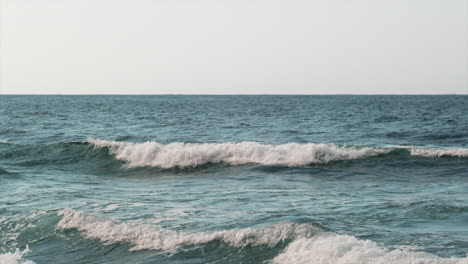 slow motion static shot of vibrant blue waves of pacific ocean