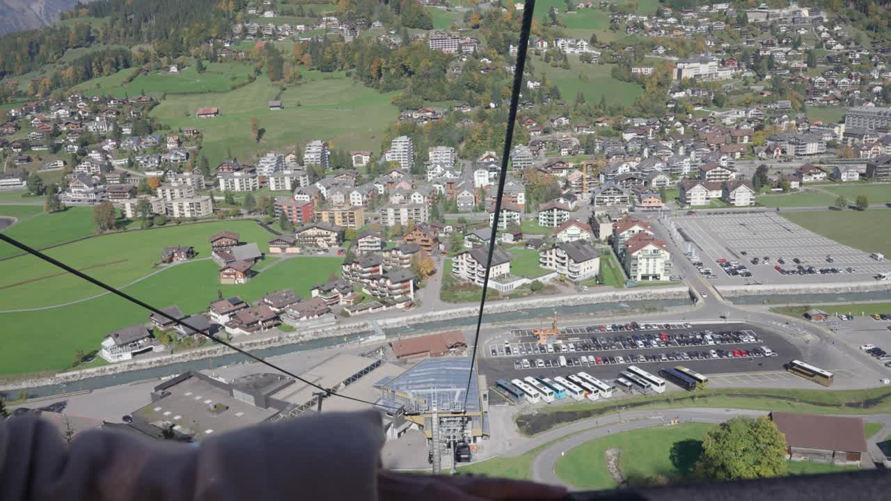 mujer mira hacia abajo en el pueblo desde el teleférico en un día soleado en engelberg, suiza