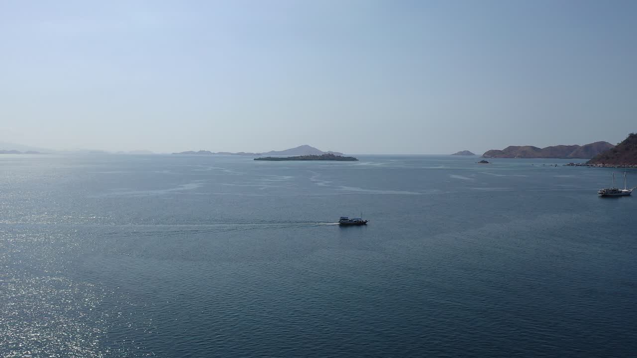광활한 바다, 산맥, 대형 선박이 순항하고, 여행하고, 태양 광선과 표면에 빛나는 광선이 있는 푸른 바다의 반짝이는 물을 타고, 정적인