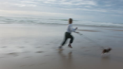 una ragazzina che corre sulla spiaggia con il suo cane