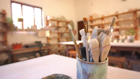 brushes and pottery tools on desk in pottery studio