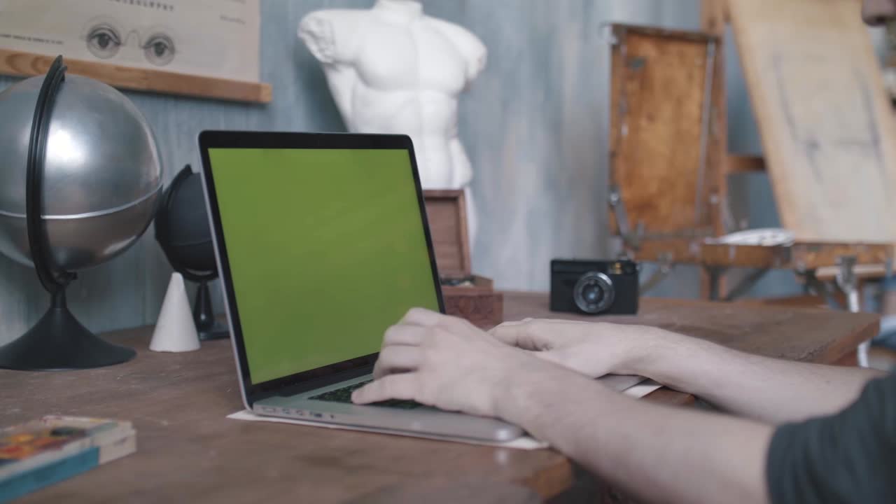 hombre trabajando en una computadora portátil en el estudio de un artista