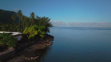 point faremahora beach coastline teahupoo tahiti french polynesia aerial drone evening sun coral reef channel surf wave judge tower paris 2024 summer olympics venue boat blue sky forward motion