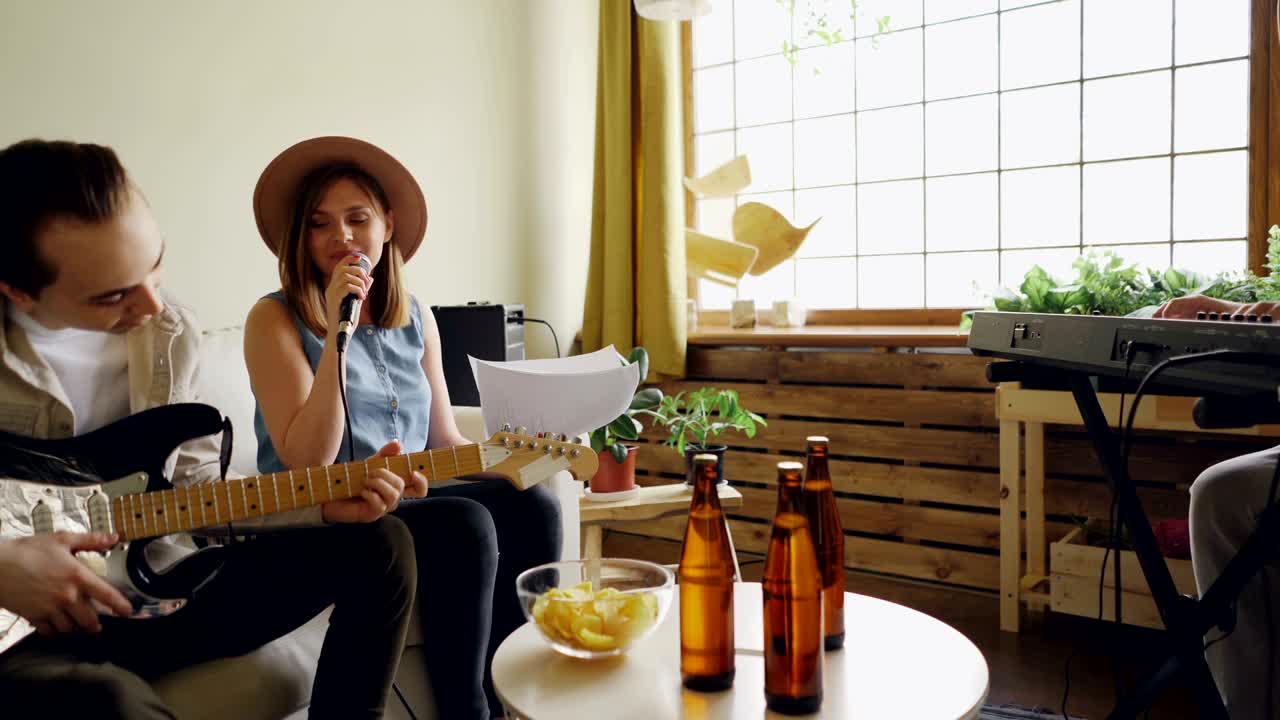 크리에이티브 밴드는 집에서 마이크와 함께 노래를 부르고 키보드와 기타를 연주하며 매력적인 사람들, 아름다운 음악과 집 내부 컨셉을 연습합니다.