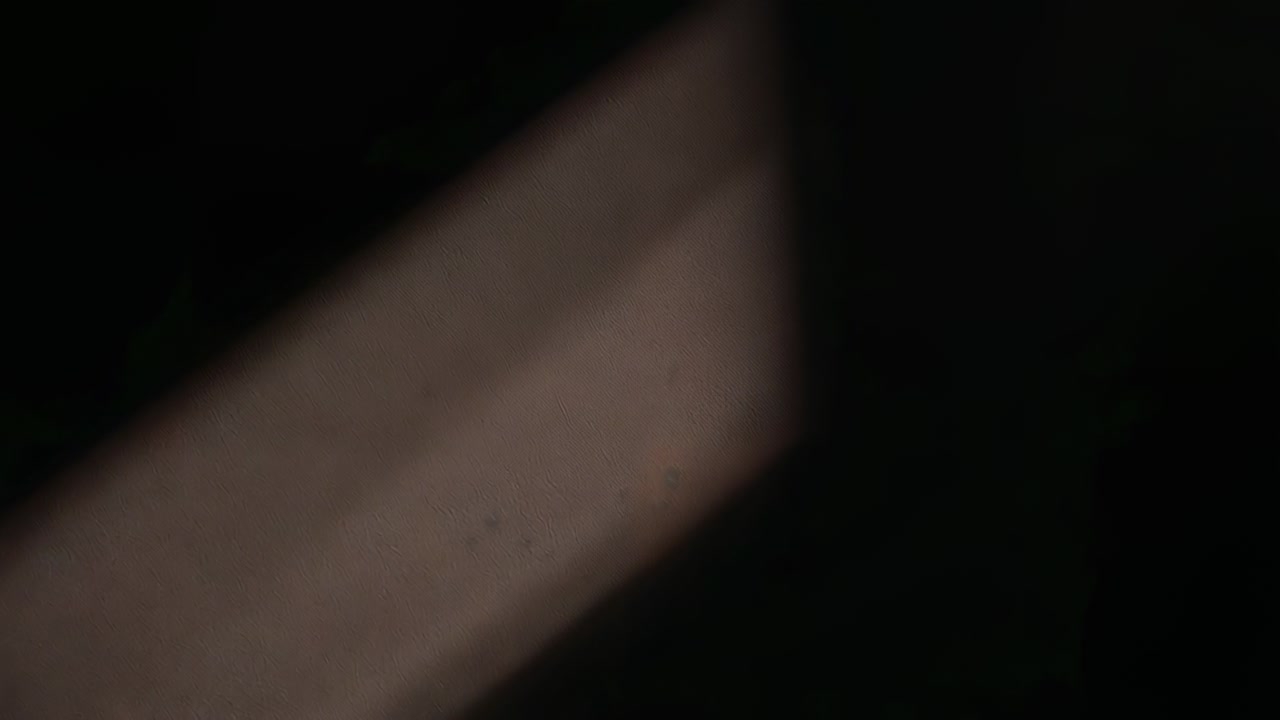 Registrazione con videocamera portatile che causa lo spostamento di una banda diagonale sfocata in una stanza poco illuminata a causa dello sfarfallio della messa a fuoco