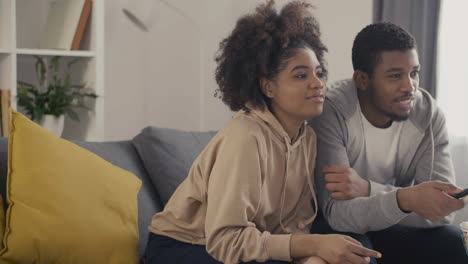 Young-Couple-Picking-Something-To-Watch-On-Tv-With-The-Remote-Control