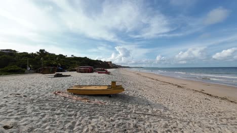 cámara de acción de mano tomada de la popular destino tropical playa del amor con arena dorada, acantilados, agua turquesa y pequeños barcos de pesca en el hermoso condé, paraíba, brasil en un día de verano