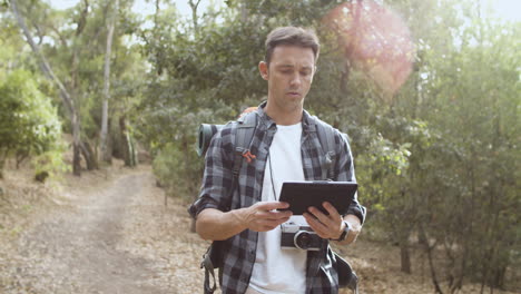 focused male backpackers walking in forest