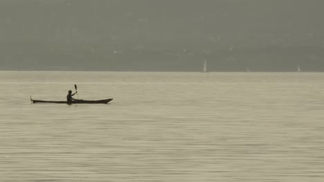 a man crossing with his canoe on lake balaton