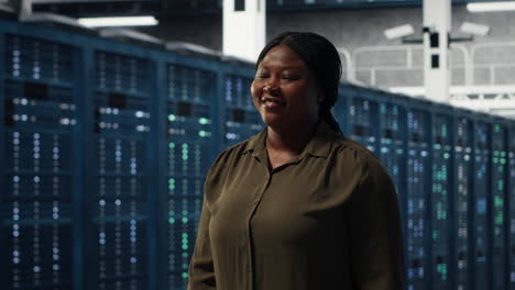 portrait of smiling admin walking in data center, overseeing it infrastructure