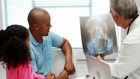 médico masculino discutiendo el informe de rayos x con el paciente