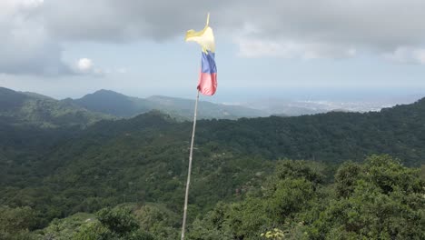 drone rodea la bandera colombiana en el lado de las montañas de la sierra nevada