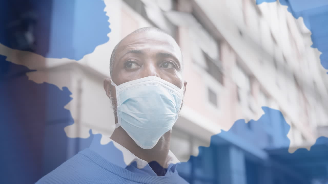 bandera de la antártida ondeando contra el hombre que lleva la máscara de la cara