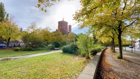 fall season in berlin with beautiful church under blue sky in park