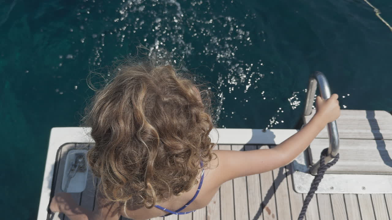 small girl on the swim deck of a yacht in greece