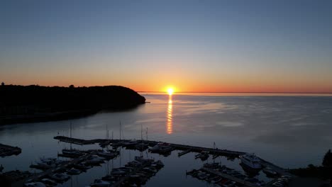 Timelapse-drone-shot-of-sister-bay,-wisconsin-at-golden-hour-in-the-fall-with-boats