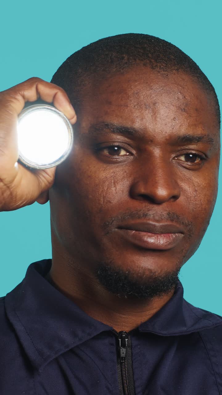 African American Man Holding Flashlight to His Head, Thinking