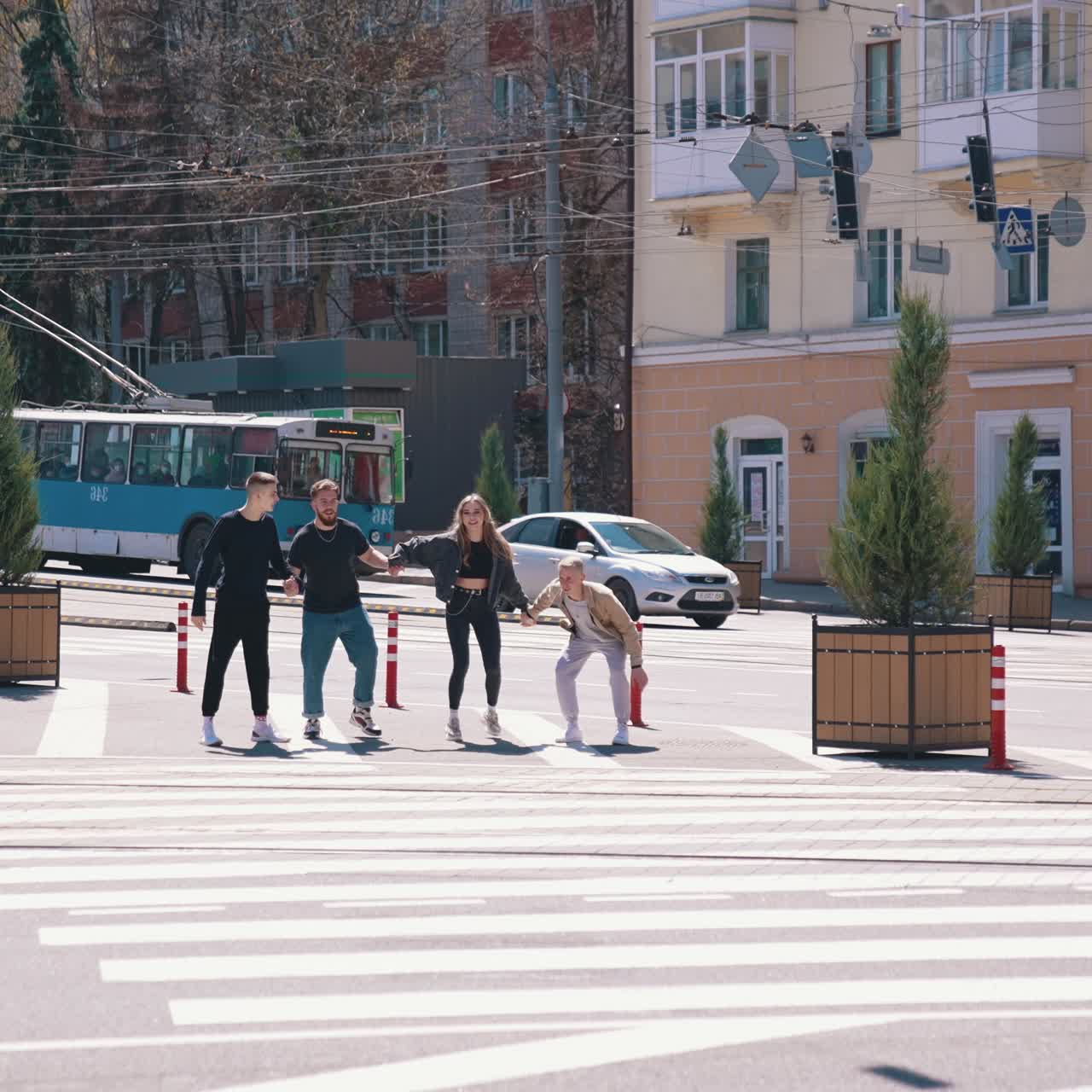 Young people in the city. Friends having fun together on urban background. Happy teenagers jumping at the same time near the road. Youth lifestyle