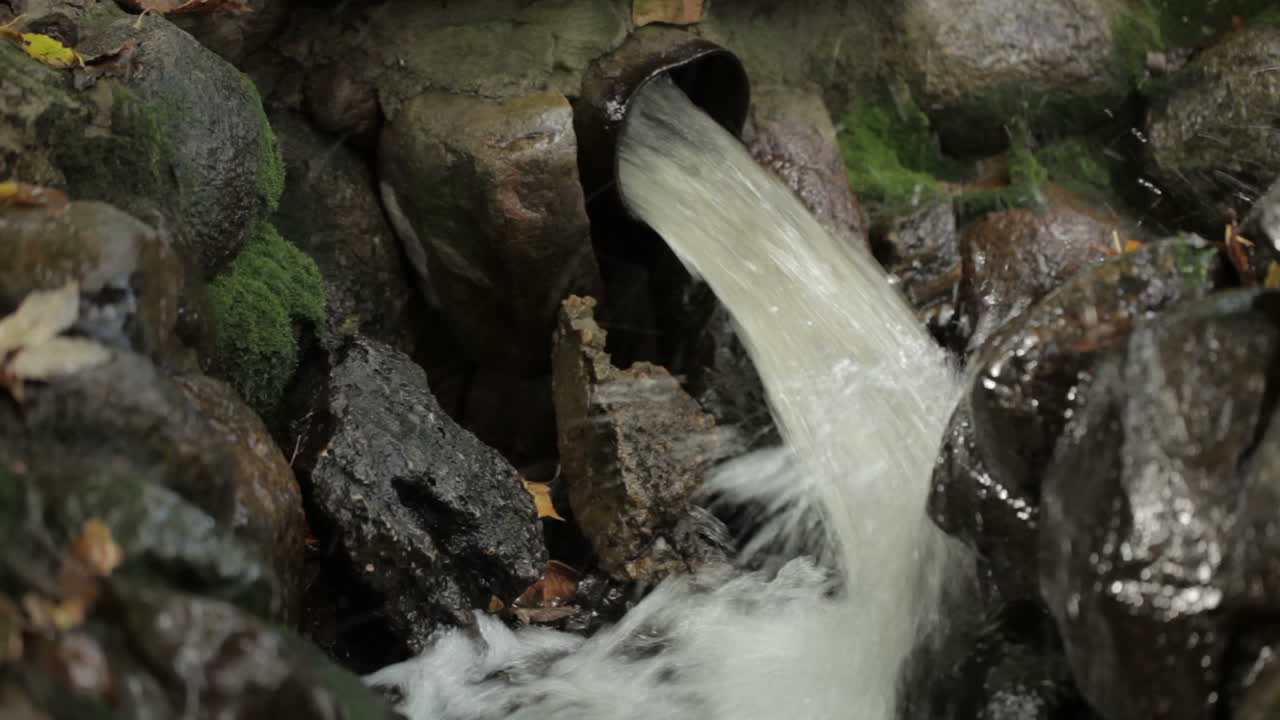 Water pours from a pipe in the city park