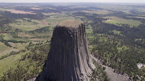 A-drone-shot-of-Devils-Tower,-a-massive,-monolithic,-volcanic-stout-tower,-or-butte,-located-in-the-Black-Hills-region-of-Wyoming