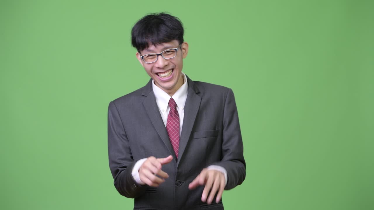 젊은 행복한 아시아 사업가 배를 들고 웃고