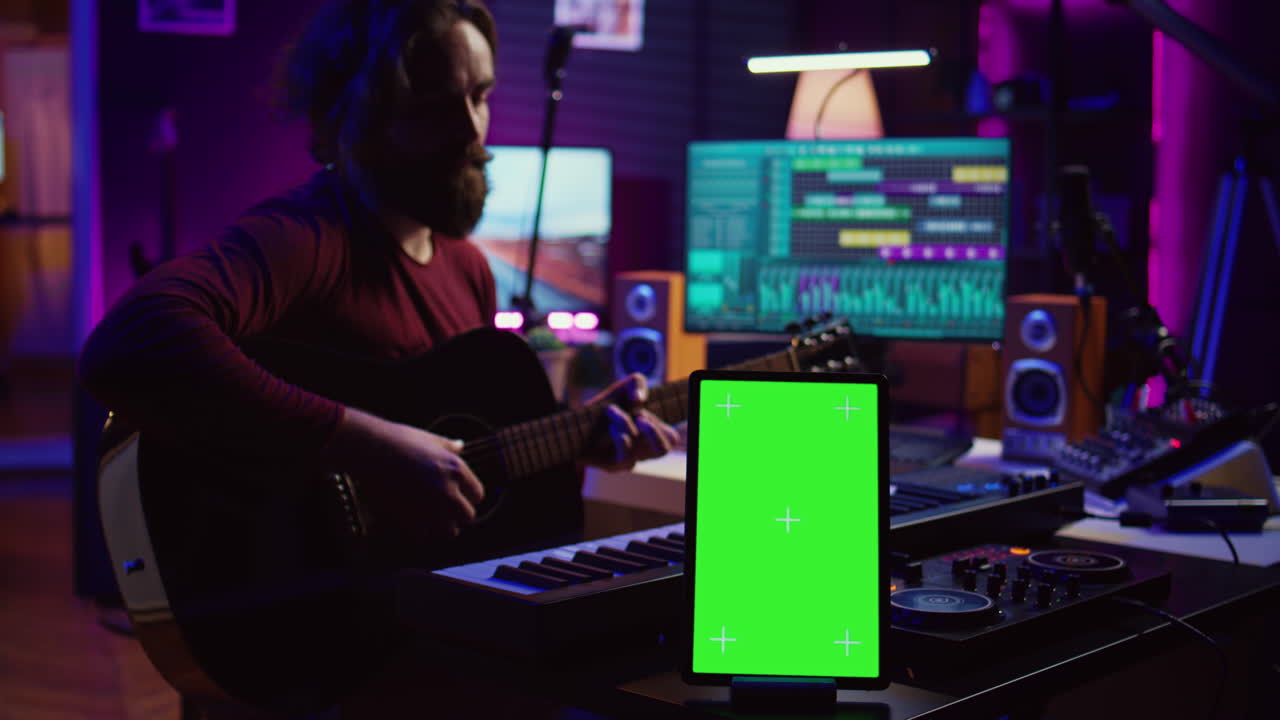 Composer performing acoustical guitar in his home studio
