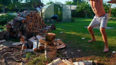 shirtless man chopping firewoods with full force