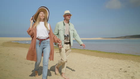 Couple-holding-hands-and-walking-on-beach