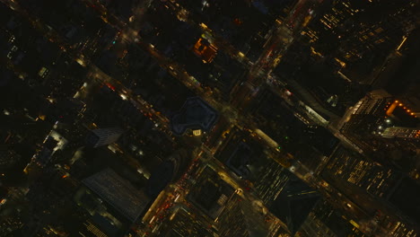 Aerial-birds-eye-overhead-top-down-view-street-grid-from-height.-Illuminated-roads-between-blocks-of-tall-buildings-in-night-city.-Manhattan,-New-York-City,-USA