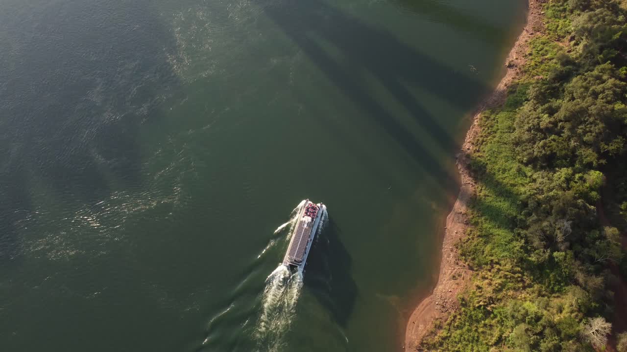 Giro turistico in barca lungo il fiume Iguazu al tramonto, al confine tra Argentina e Brasile.