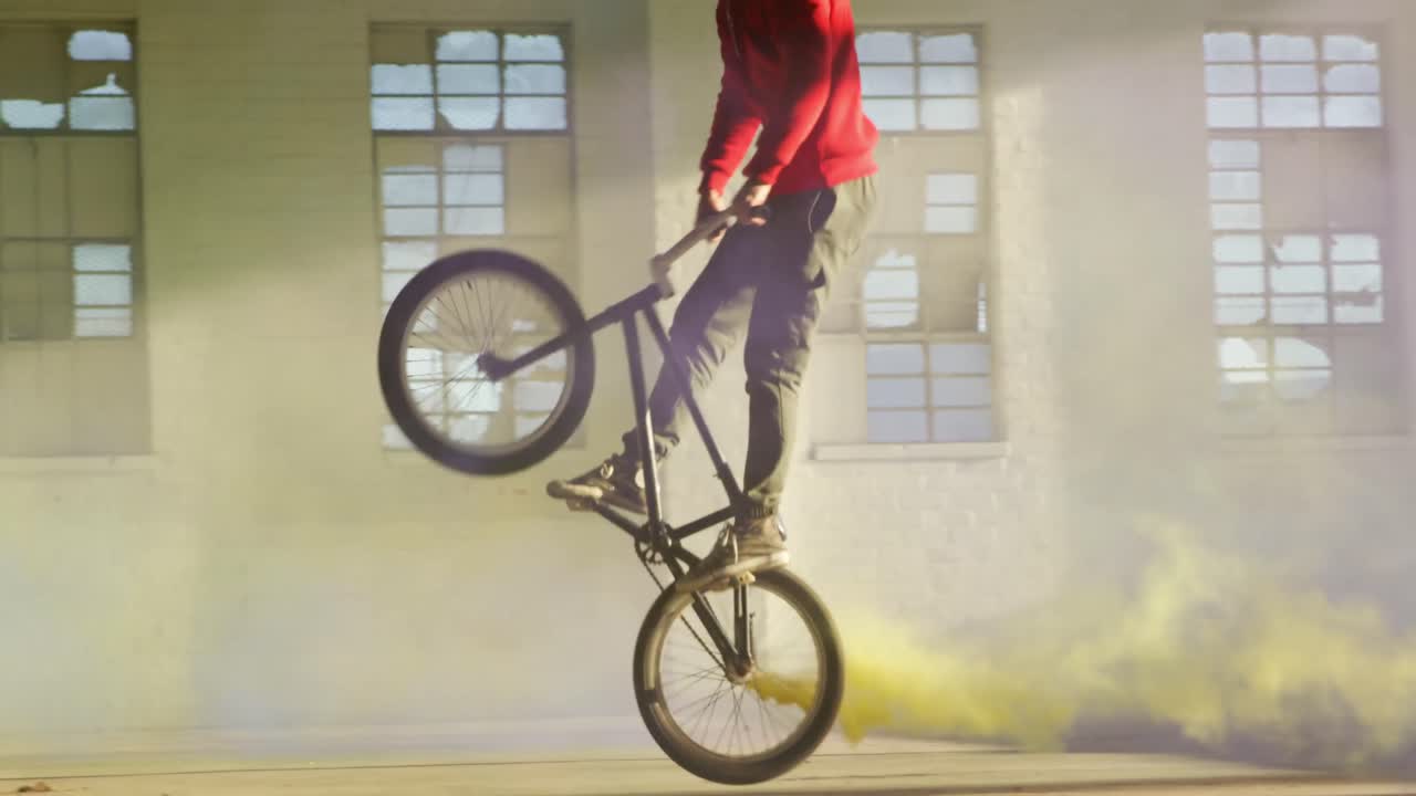 연기 수류탄 을 사용하는 빈 창고 에 있는 bmx 라이더 들