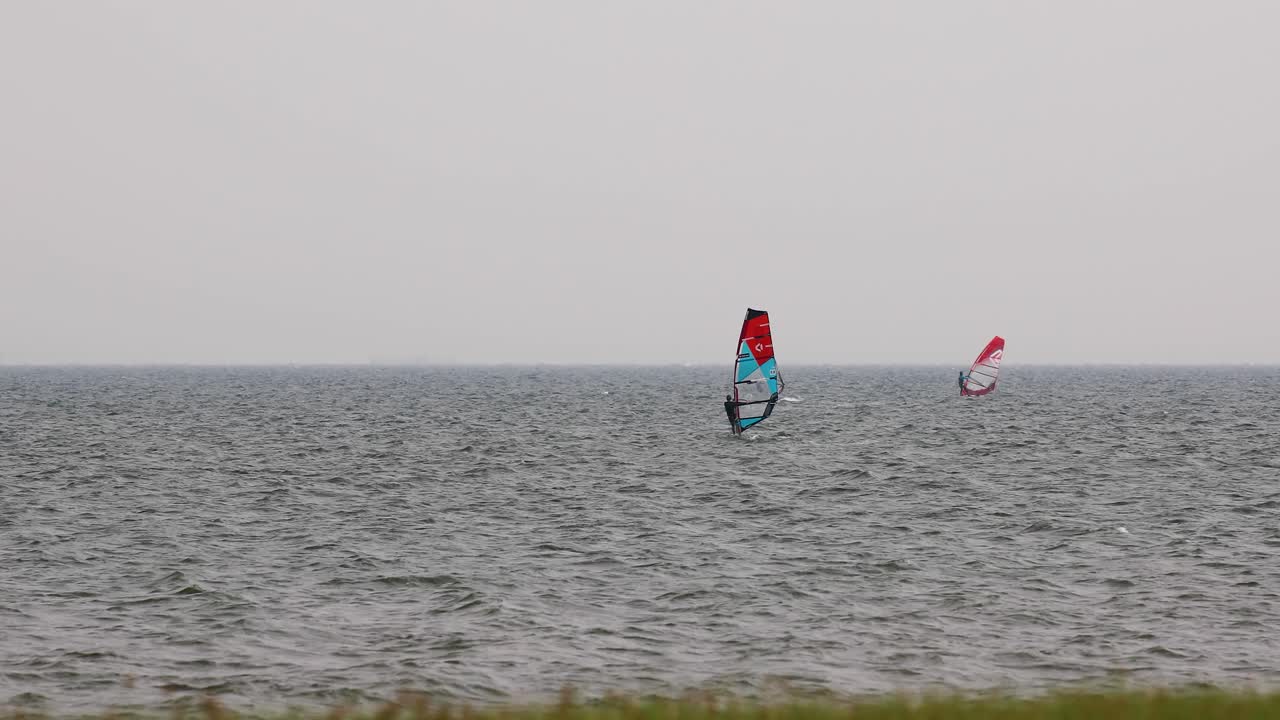 grupo de windsurfistas navegando en el viento frente a la costa de pattaya, tailandia