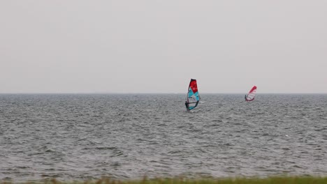 group of wind surfers sailing in the wind off the coast of pattaya, thailand