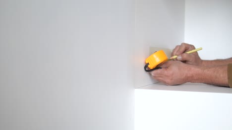 man measuring wall for installation