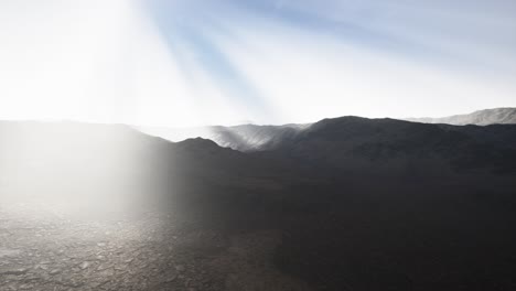 sun rays over mountains in a valley