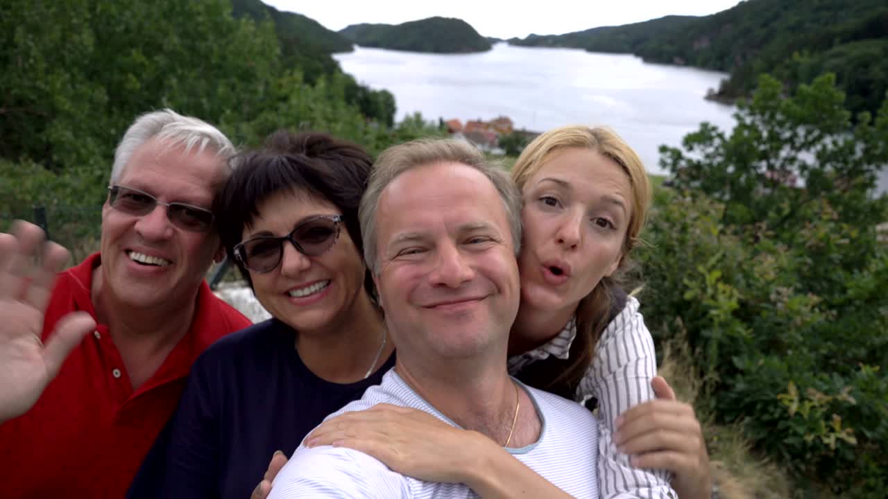 큰 행복한 가족은 셀피를 찍거나 해변에서 전화 비디오 통화 카메라를 사용합니다.