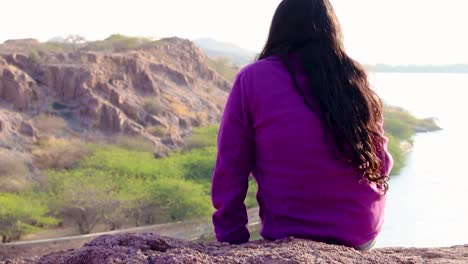 isolated-young-girl-at-mountain-top-with-lake-view-backbit-shot-from-flat-angle-video-is-taken-at-kaylana-lake-jodhpur-rajasthan-india