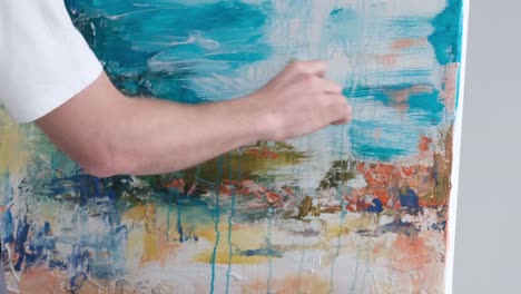 artist creating abstract painting on canvas
