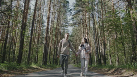 couple walking hand-in-hand through a forest