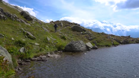 Wanderer,-Der-An-Einem-Sonnigen,-Aber-Windigen-Tag-Entlang-Eines-Alpensees-Mit-Dem-Mont-Blanc-Im-Hintergrund-Wandert