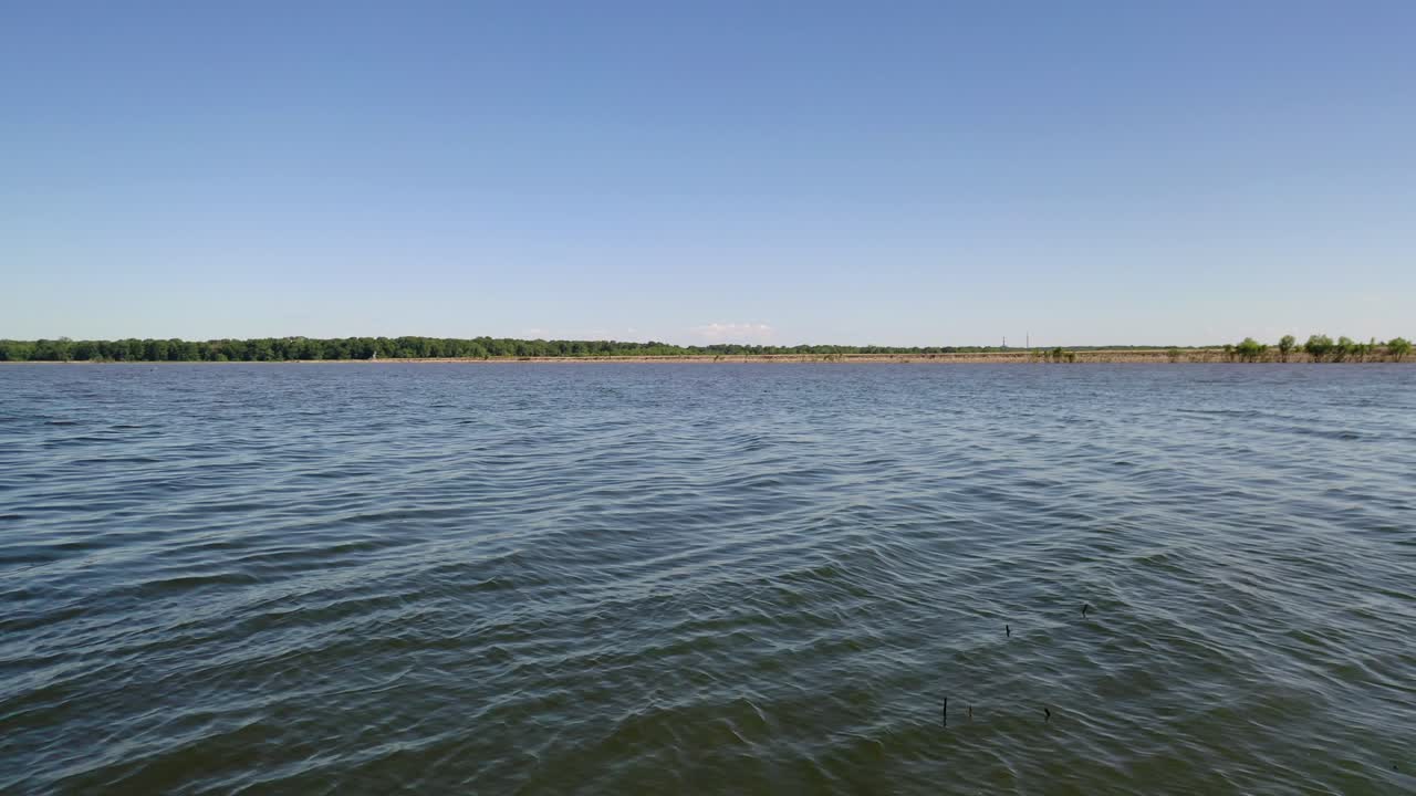 toma aérea desde la línea de la costa a través del lago con el horizonte