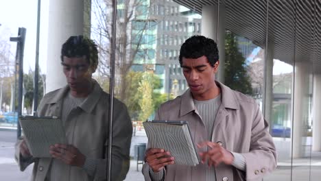 Stylish-ethnic-man-with-tablet-on-street