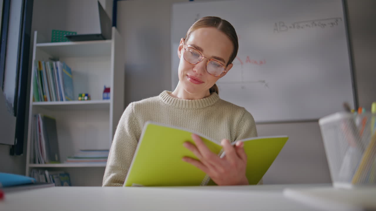 Lady teacher looking window at workplace closeup. Happy tutor checking homework