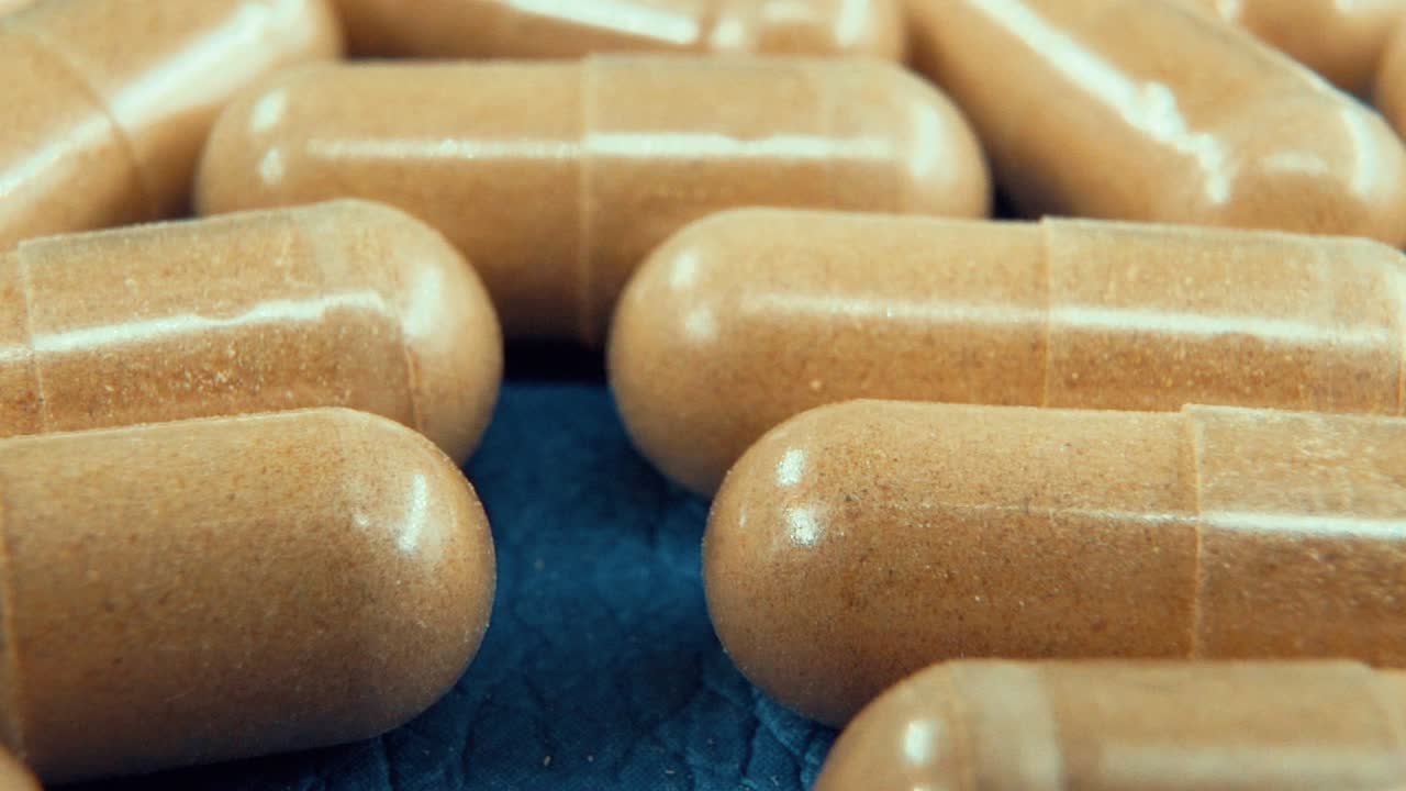 una cámara macro cinematográfica en cámara lenta en un laboratorio de una cápsula médica con polvo, píldoras orgánicas, luz de estudio, 120 fps, full hd