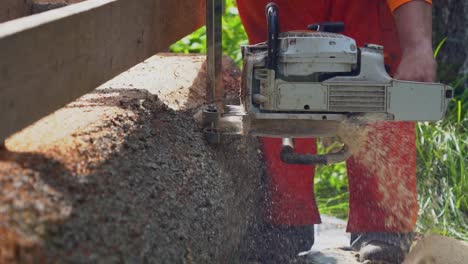 Toma-Media-En-Cámara-Lenta-Mirando-Hacia-Abajo-A-Lo-Largo-De-Un-Tronco-En-Un-Molino-De-Losa-De-Motosierra-De-Bricolaje-Mientras-Cae-Aserrín