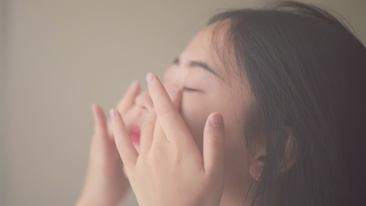 피자마를 입은 아름다운 여성의 피부 관리 피부 관리 얼굴이 건강 관리 제품을 적용하여 깨어나며, 웰니스 신체 관리 및 미용을 위해  바탕에 고립됩니다.