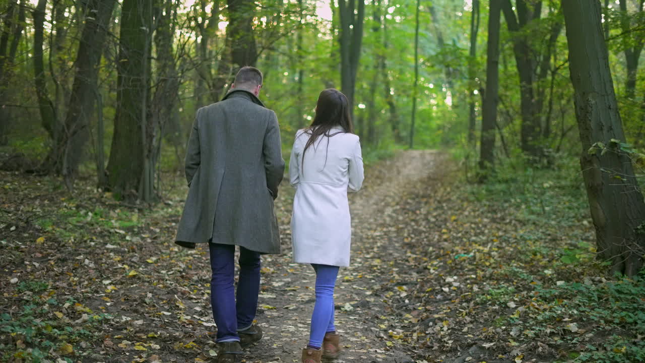 가을의 숲에서 산책하는 부부