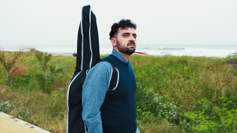 guitar player walking on the bike path with the guitar on his back